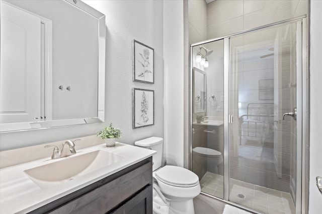 full bathroom with vanity, a shower stall, and toilet