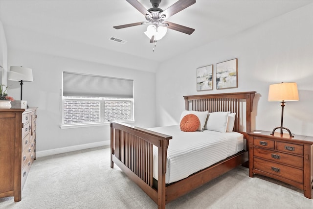 bedroom featuring a ceiling fan, visible vents, light carpet, and baseboards