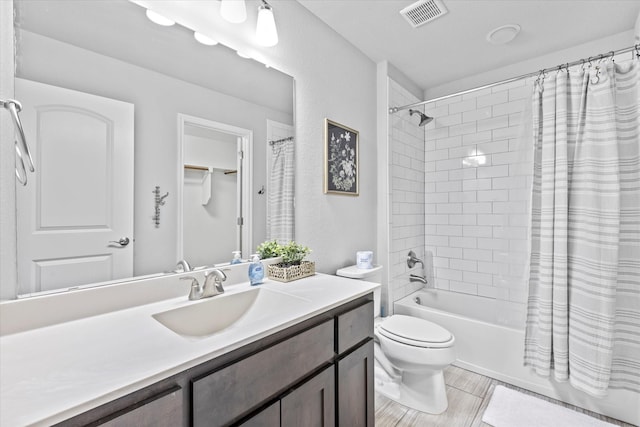 full bathroom featuring visible vents, a textured wall, toilet, shower / tub combo, and vanity