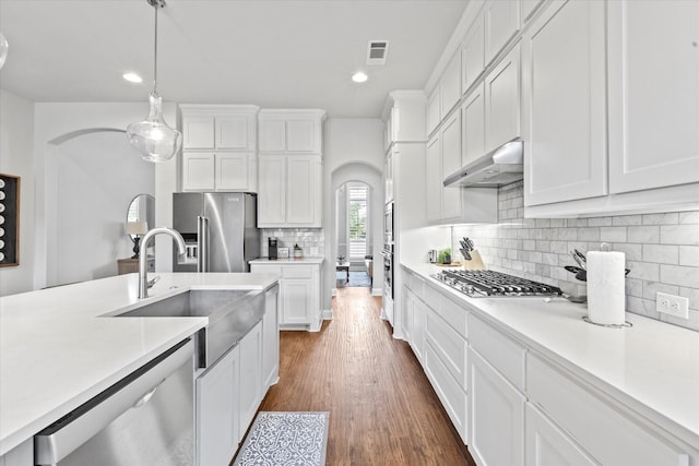 kitchen featuring stainless steel appliances, light countertops, visible vents, and under cabinet range hood