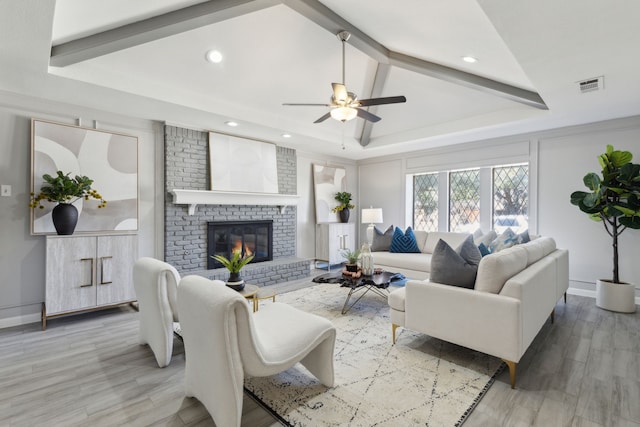 living room with baseboards, visible vents, wood finished floors, vaulted ceiling with beams, and a fireplace