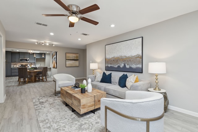 living area featuring baseboards, recessed lighting, visible vents, and light wood-style floors