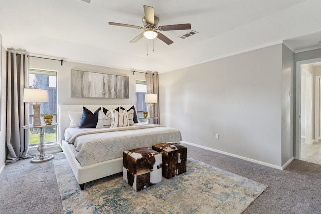 carpeted bedroom with ornamental molding, visible vents, baseboards, and a ceiling fan