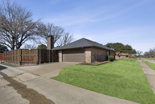 view of side of property with an attached garage, brick siding, fence, a yard, and driveway