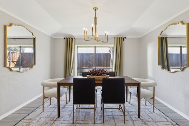 dining room featuring a chandelier, baseboards, and wood finished floors