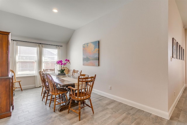 dining room with light wood-type flooring, baseboards, vaulted ceiling, and recessed lighting