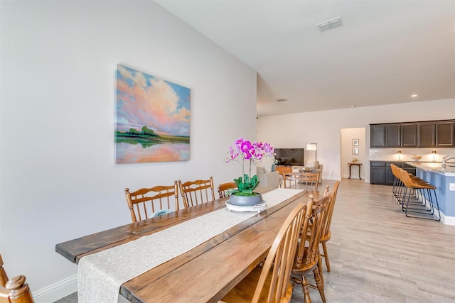 dining room featuring light wood-type flooring, visible vents, baseboards, and recessed lighting