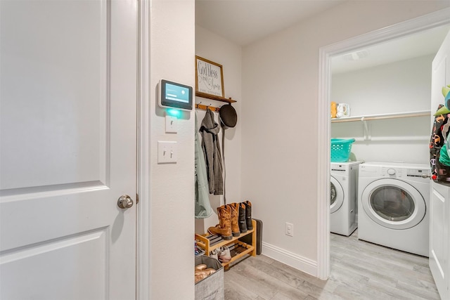 laundry room featuring laundry area, baseboards, light wood finished floors, and independent washer and dryer