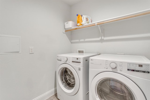 clothes washing area with laundry area, washing machine and clothes dryer, and baseboards