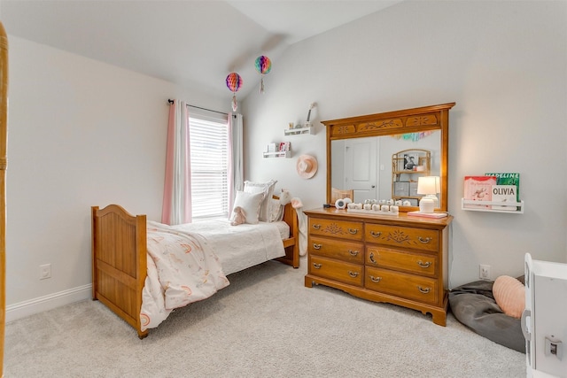 bedroom with lofted ceiling and light colored carpet