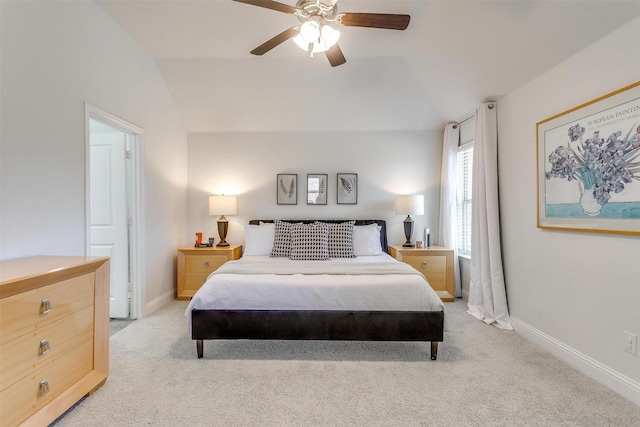 bedroom with baseboards, vaulted ceiling, and light colored carpet