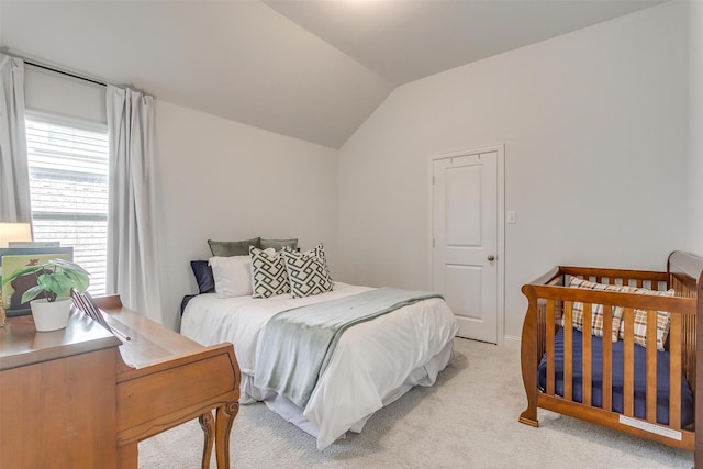 bedroom with lofted ceiling and light carpet