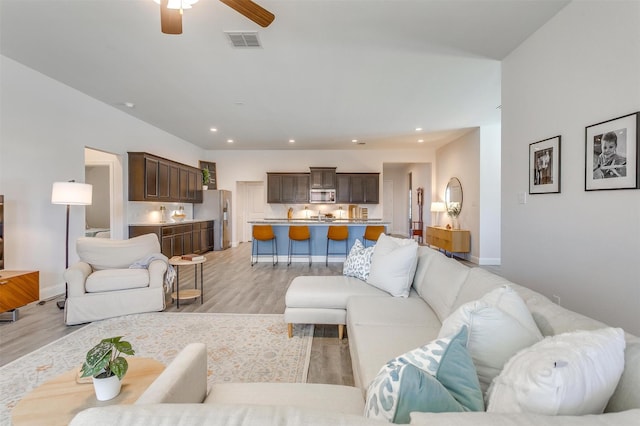 living area featuring light wood-style floors, baseboards, visible vents, and recessed lighting