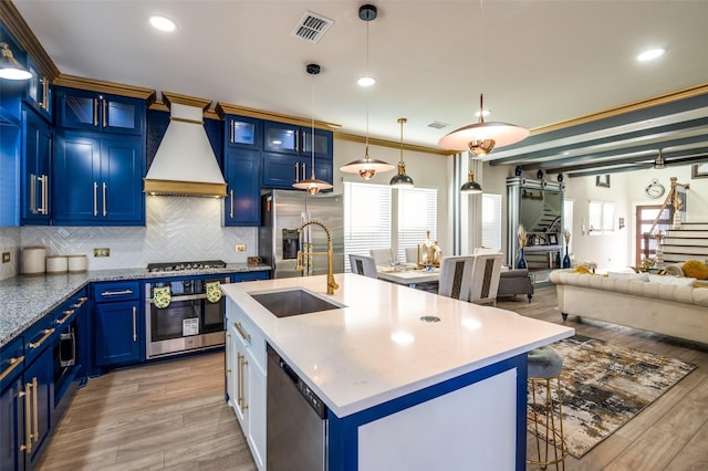 kitchen with blue cabinets, visible vents, open floor plan, appliances with stainless steel finishes, and ornamental molding