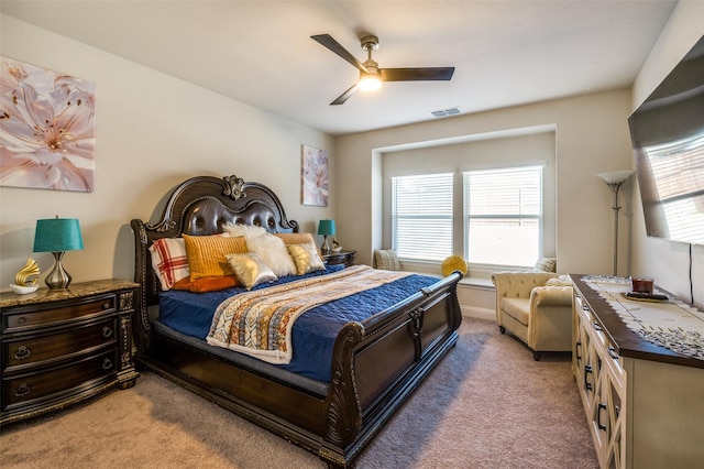 bedroom featuring light carpet, ceiling fan, visible vents, and multiple windows