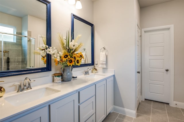 full bathroom with a stall shower, double vanity, a sink, and tile patterned floors