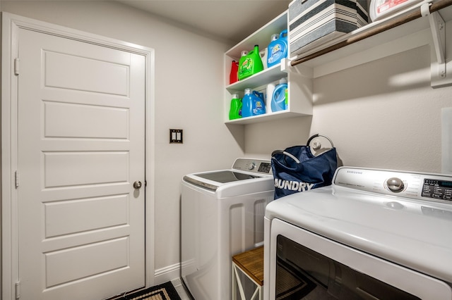 washroom with laundry area, baseboards, and separate washer and dryer