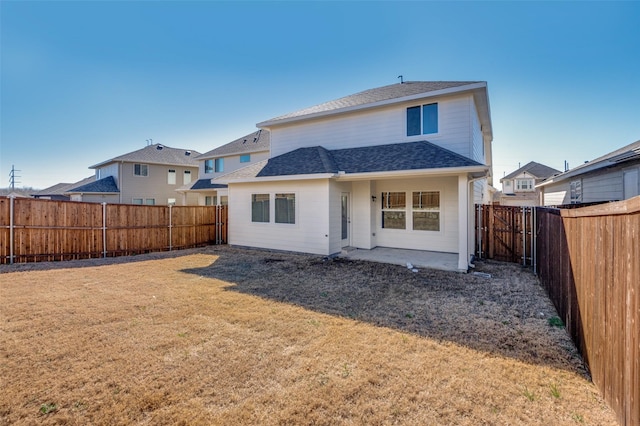 back of property featuring a patio, a lawn, a fenced backyard, and roof with shingles