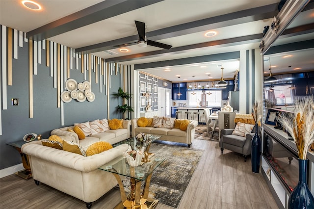 living room featuring a ceiling fan, beamed ceiling, and wood finished floors