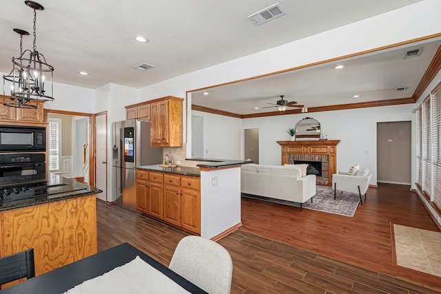 kitchen featuring black appliances, dark wood-type flooring, a fireplace, and visible vents