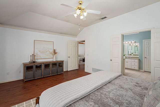 bedroom featuring lofted ceiling, visible vents, a sink, and light wood-style flooring