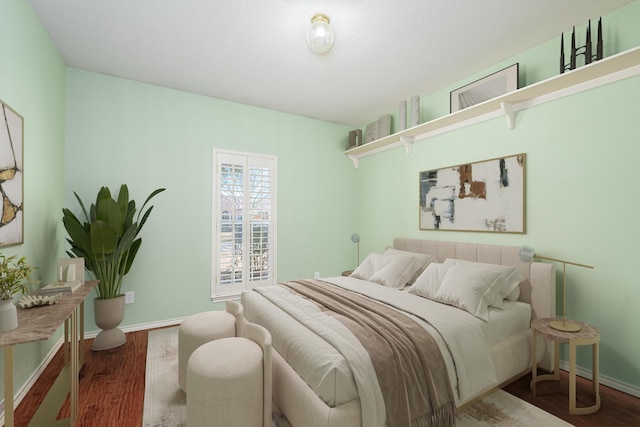 bedroom with wood finished floors and baseboards