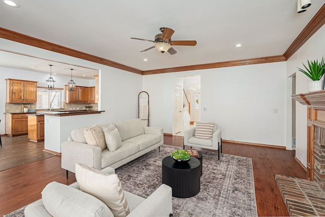 living area with crown molding, dark wood finished floors, recessed lighting, a ceiling fan, and stairs