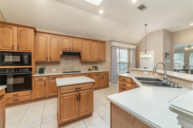 kitchen featuring tasteful backsplash, a kitchen island, light countertops, black appliances, and a sink