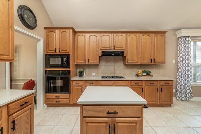 kitchen with decorative backsplash, light countertops, under cabinet range hood, and black appliances