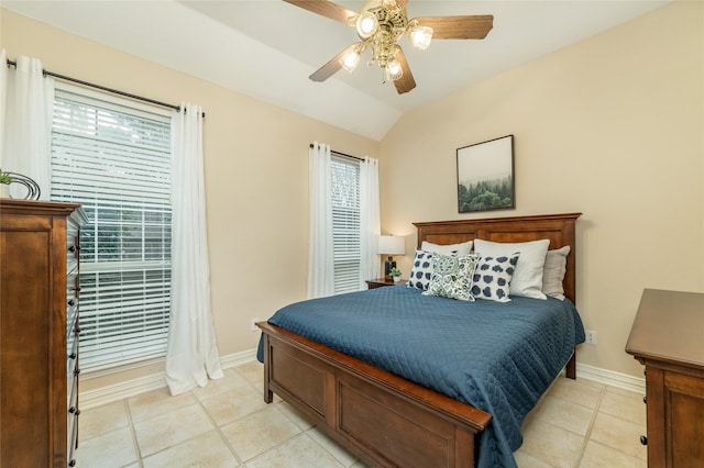 bedroom with light tile patterned flooring, vaulted ceiling, baseboards, and multiple windows