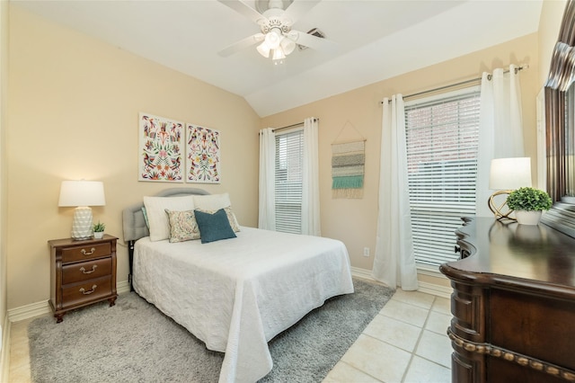 bedroom with multiple windows, baseboards, vaulted ceiling, and light tile patterned flooring