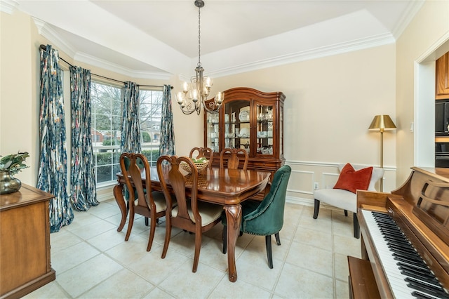 dining space featuring a wainscoted wall, an inviting chandelier, crown molding, a decorative wall, and light tile patterned flooring