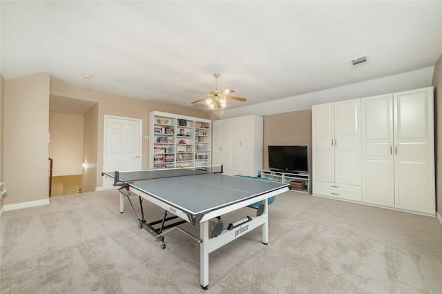 recreation room featuring light colored carpet, ceiling fan, visible vents, and baseboards