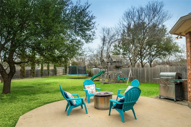 view of jungle gym featuring a patio, a yard, a trampoline, and a fenced backyard