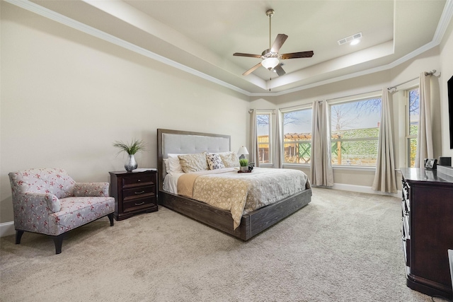 bedroom with light carpet, baseboards, visible vents, a tray ceiling, and crown molding