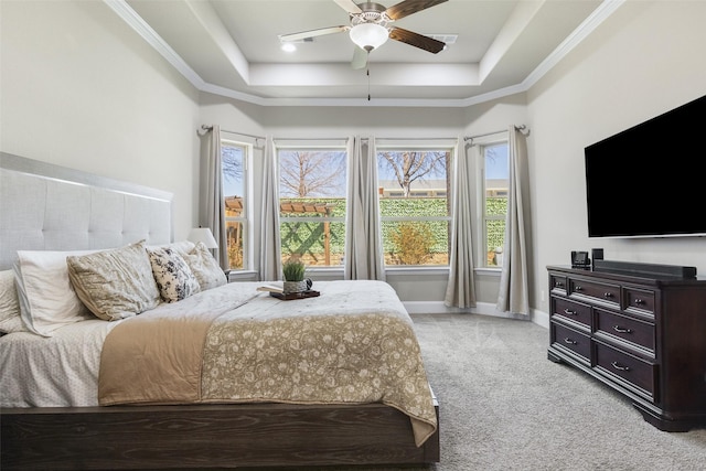 bedroom featuring light carpet, a ceiling fan, baseboards, ornamental molding, and a tray ceiling