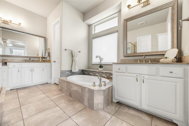 full bath with two vanities, a garden tub, and tile patterned floors