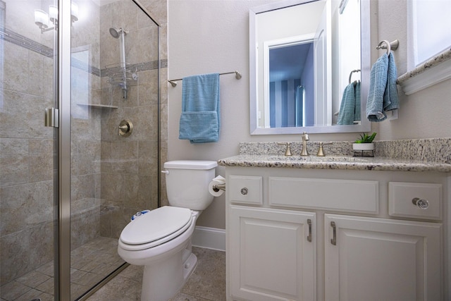 bathroom with a stall shower, vanity, and toilet