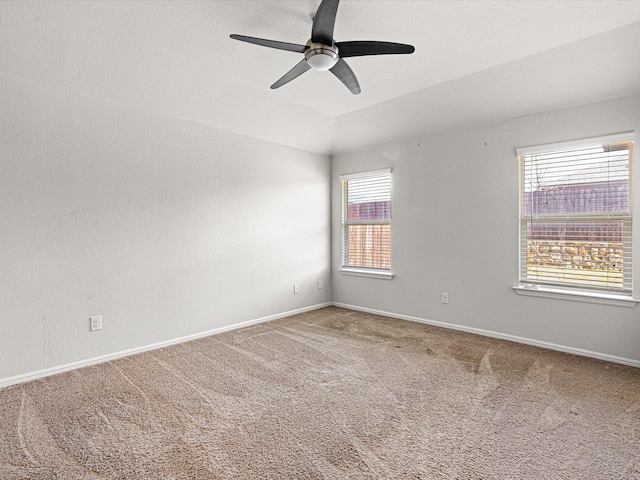 unfurnished room featuring lofted ceiling, carpet floors, a ceiling fan, and baseboards