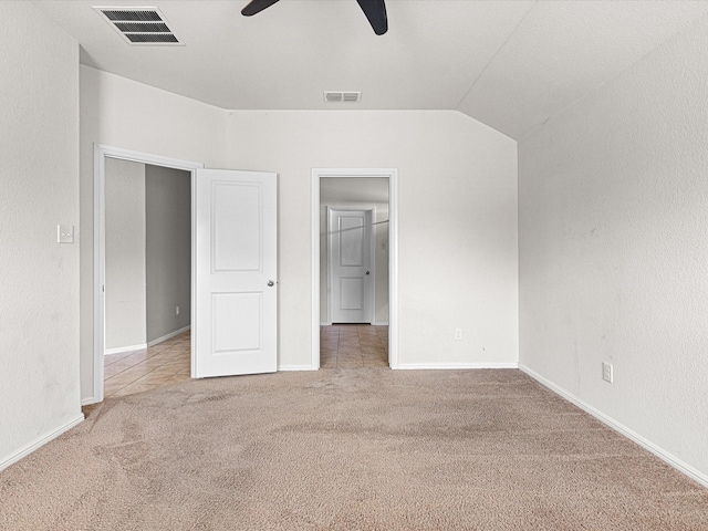 unfurnished bedroom with carpet floors, visible vents, a ceiling fan, and lofted ceiling