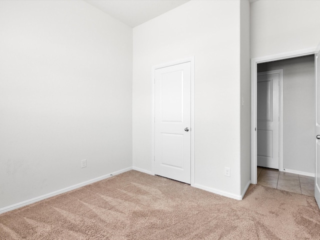 unfurnished bedroom featuring carpet floors and baseboards