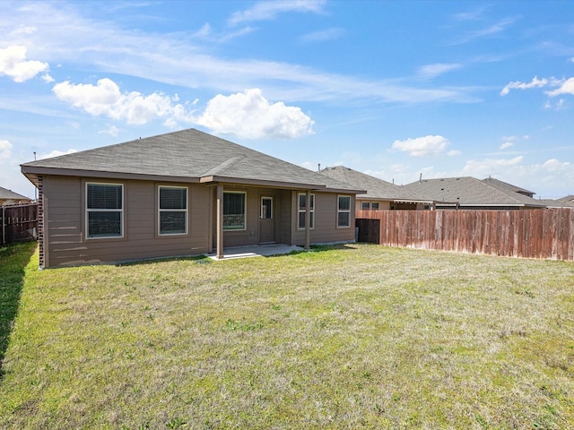 back of property with a yard, a patio area, and fence