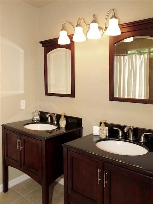 full bath with tile patterned flooring, two vanities, and a sink