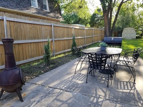 view of patio with a storage shed, outdoor dining area, an outbuilding, and a fenced backyard