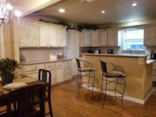 kitchen featuring a breakfast bar, dark wood finished floors, light countertops, decorative backsplash, and a sink