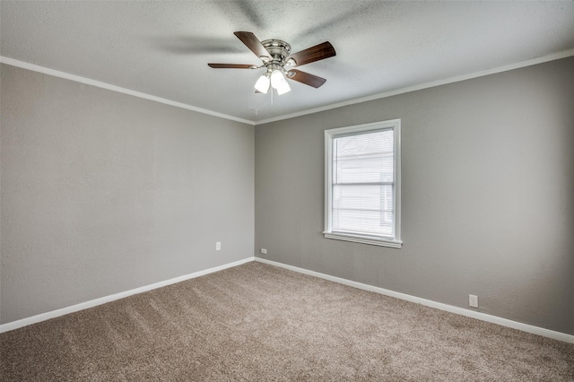 empty room featuring a textured wall, ornamental molding, a ceiling fan, carpet flooring, and baseboards