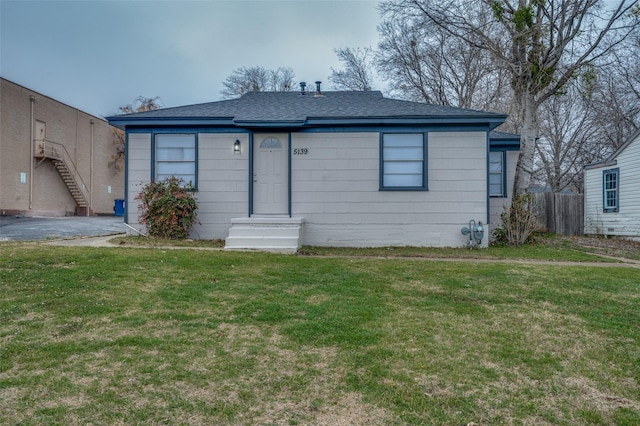 view of front facade with a front lawn and fence