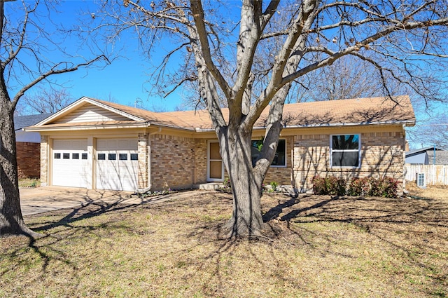 ranch-style home featuring a garage, fence, concrete driveway, and brick siding