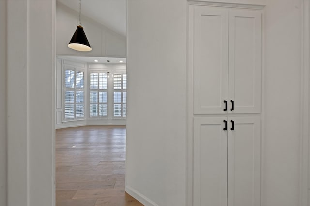 corridor featuring lofted ceiling and light wood finished floors