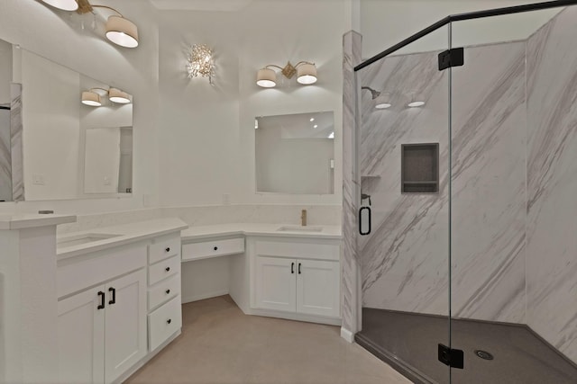 full bath with a marble finish shower, two vanities, and a sink